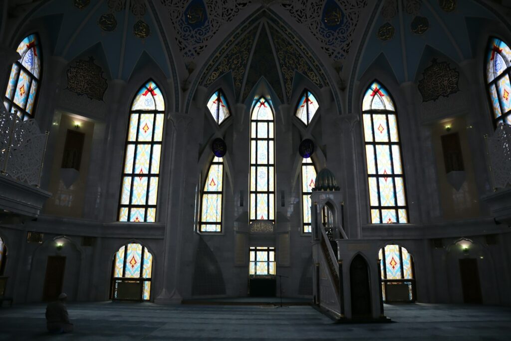 Quiet mosque prayer hall with tall windows