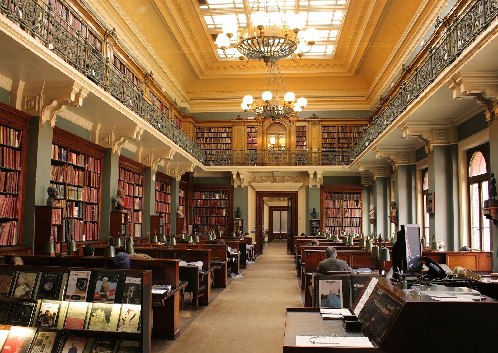 Readers seated in a grand public library reading room